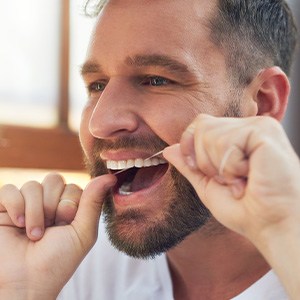 Closeup of man smiling while flossing