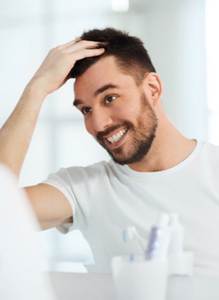 Man smiling while looking in mirror