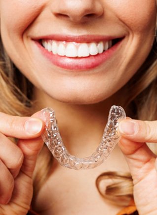 Woman placing aligners on teeth