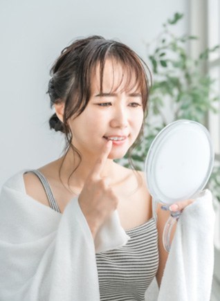 Woman looking at gums in mirror