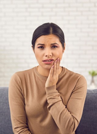 Woman in pain while holding jaw