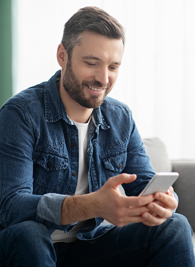 Man smiling while scrolling on his phone