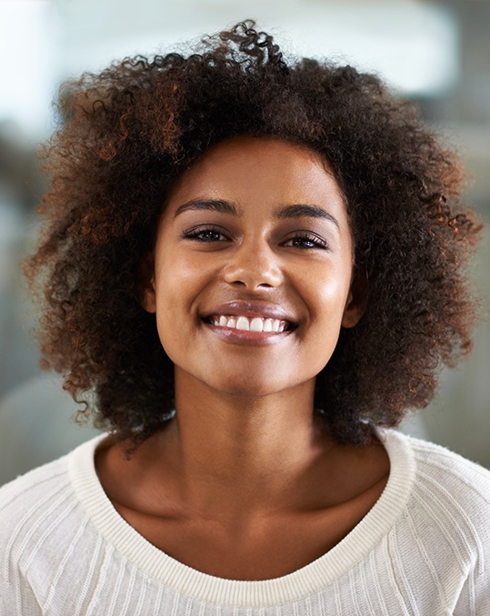 A smiling young woman looking right at the camera