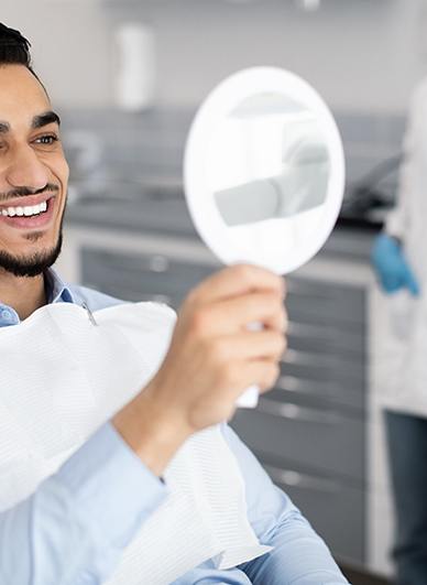 A handsome man looking at his treated teeth