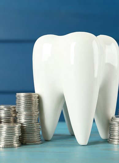 A large ceramic tooth surrounded by stacks of silver coins