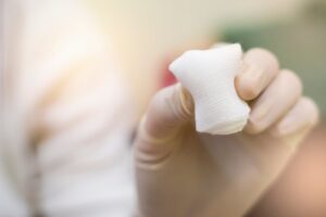 Hand holding gauze.