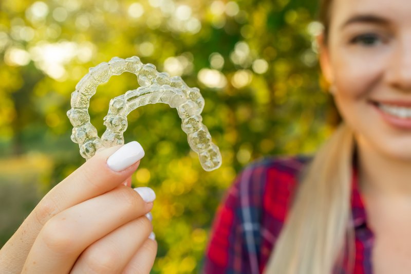 Lady presents her Invisalign clear aligners